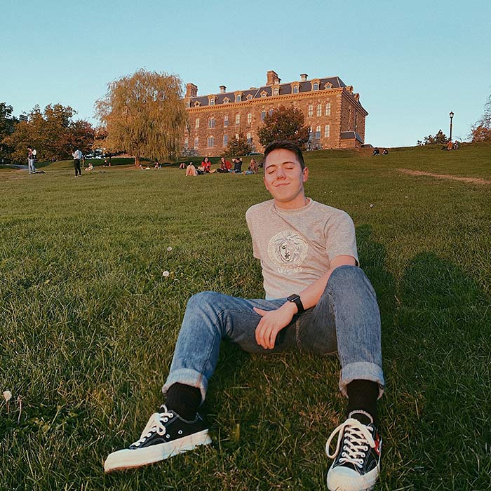 Clay sitting and enjoying the sunlight on a campus lawn